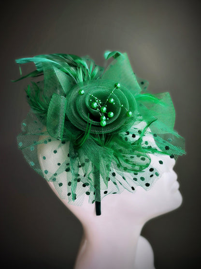 Green tea party fascinator hat with floral center, feathers, and dotted tulle

