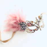Gold and black men’s mask with matching girl’s gold filigree pink feather masquerade mask.