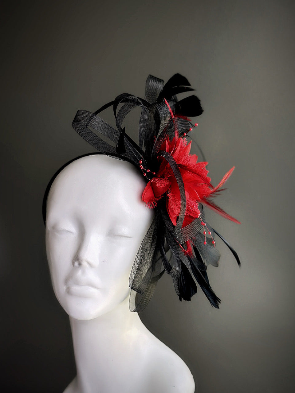 Red and black feather tulle fascinator hat with floral and looped detailing
