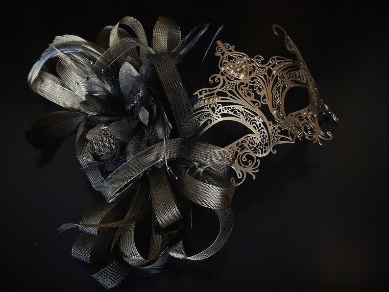 Elegant gold and black masquerade mask with feathers and filigree lace metal, perfect for balls, proms, and Venetian carnival events.