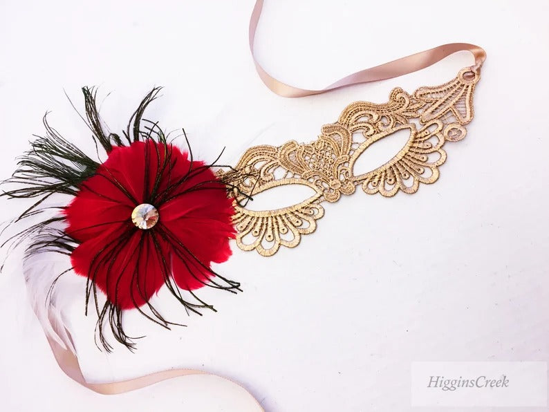 Elegant gold lace masquerade mask with red feathers and rhinestone accent for women’s prom, Mardi Gras, and costume events.