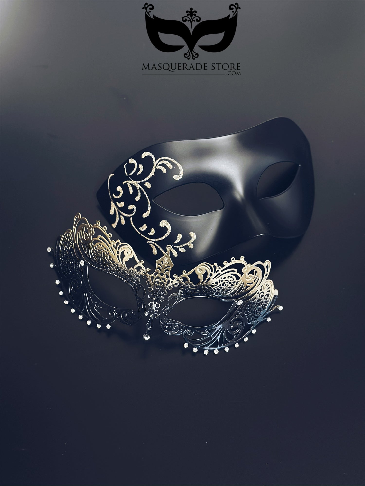 Black and gold couples masquerade masks with matte black mask with filigree detailing for men and gold ombre laser-cut metal mask for women.
