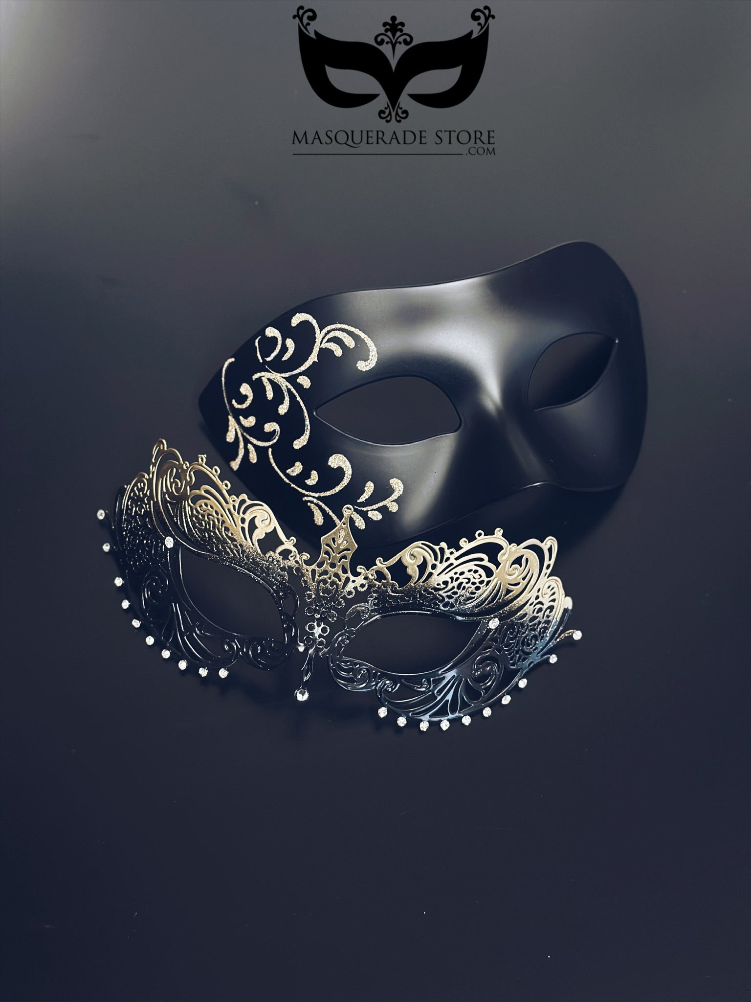 Black and gold couples masquerade masks with matte black mask with filigree detailing for men and gold ombre laser-cut metal mask for women.