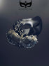 Black and gold couples masquerade masks with matte black mask with filigree detailing for men and gold ombre laser-cut metal mask for women.