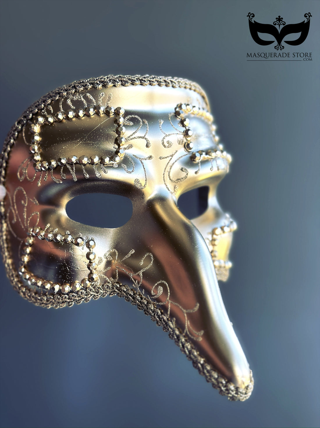 Gold plague doctor masquerade mask with long nose and ornate trim, inspired by Venetian Carnival traditions.