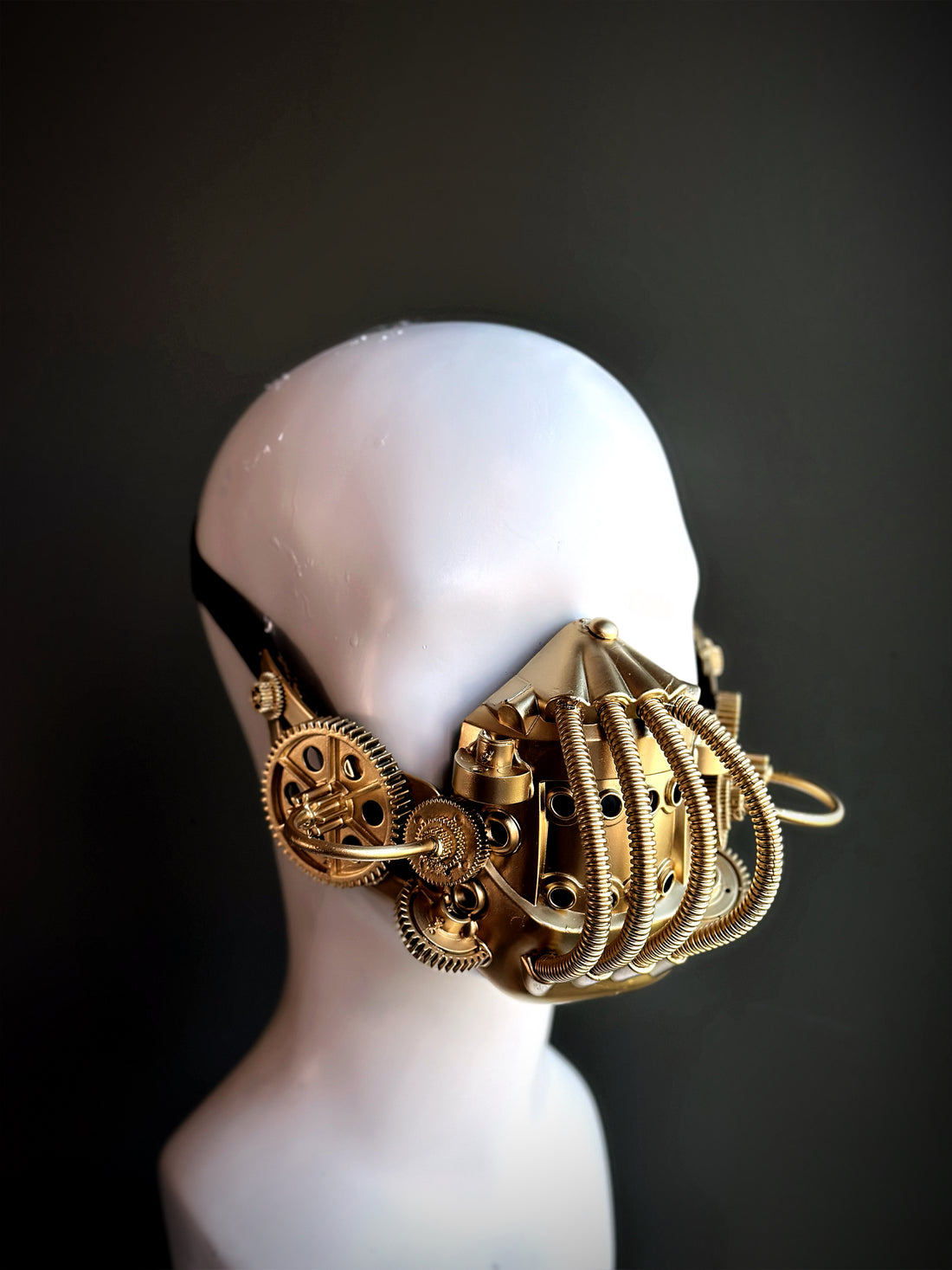 Gold steampunk respirator mask featuring gears, tubing, and industrial details, ideal for cosplay, gothic, and cyberpunk fashion.

