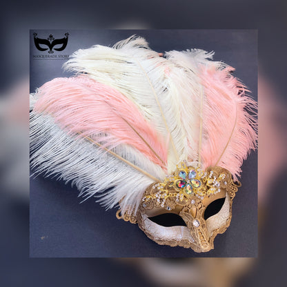 Golden mask adorned with blush and ivory ostrich feathers, gold lace, and sparkling rhinestones, ideal for glamorous events and masquerades.