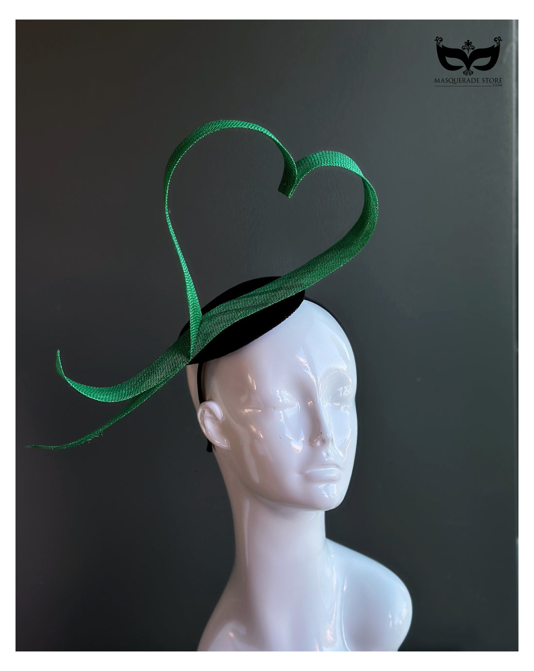 Green heart loop fascinator headband with sculptural ribbon design on mannequin