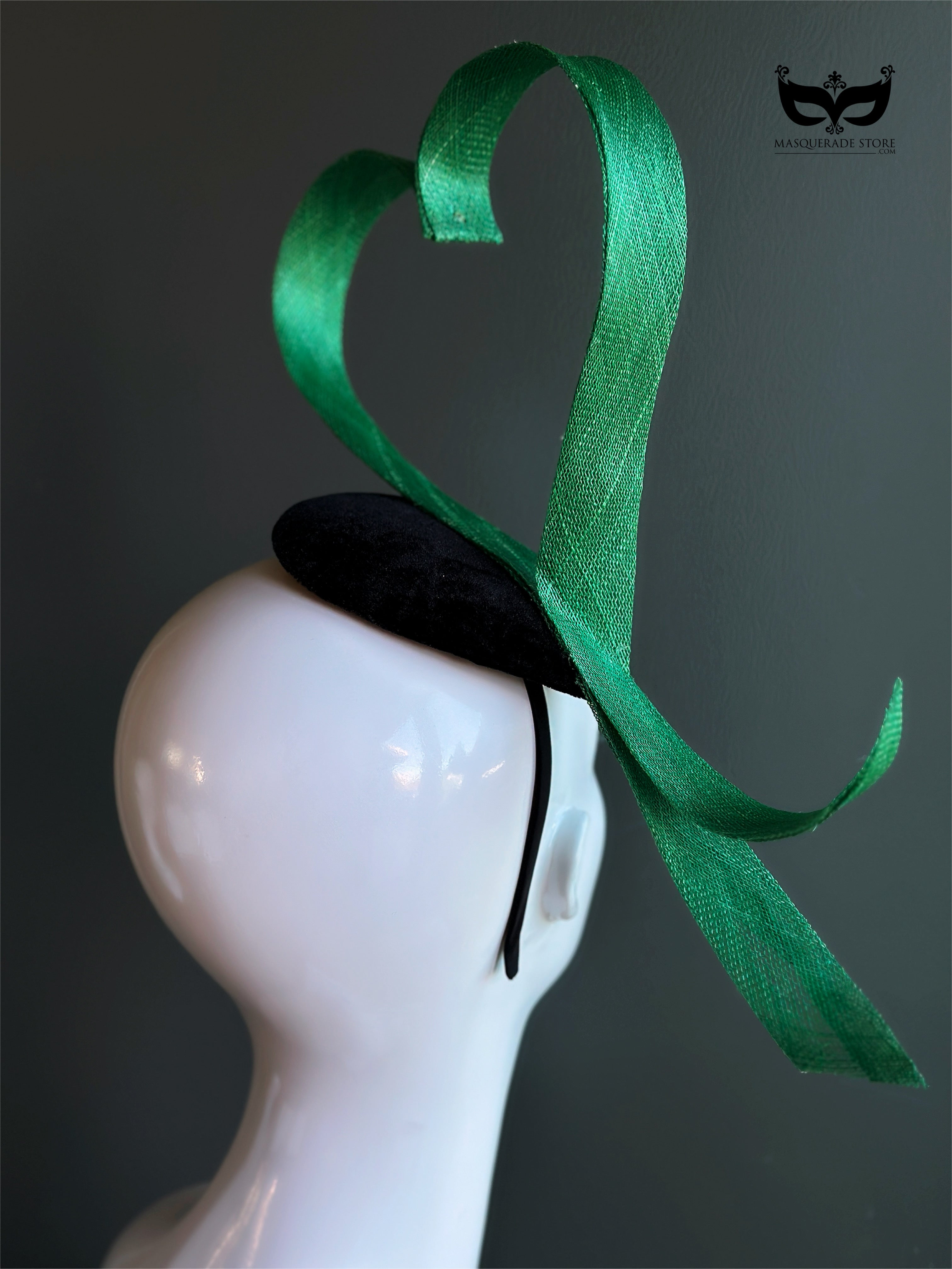 Green heart loop fascinator headband with sculptural ribbon design on mannequin