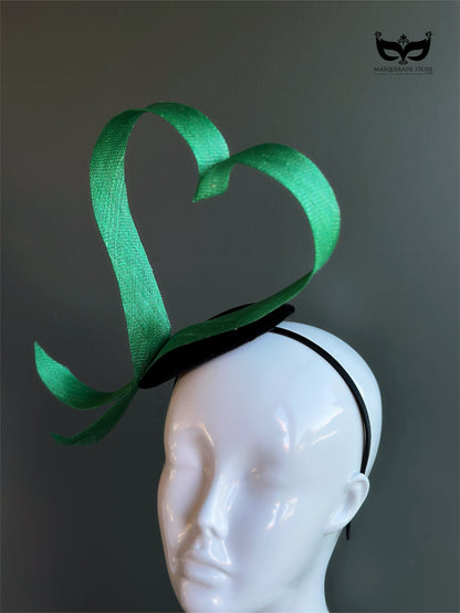 Green heart loop fascinator headband with sculptural ribbon design on mannequin