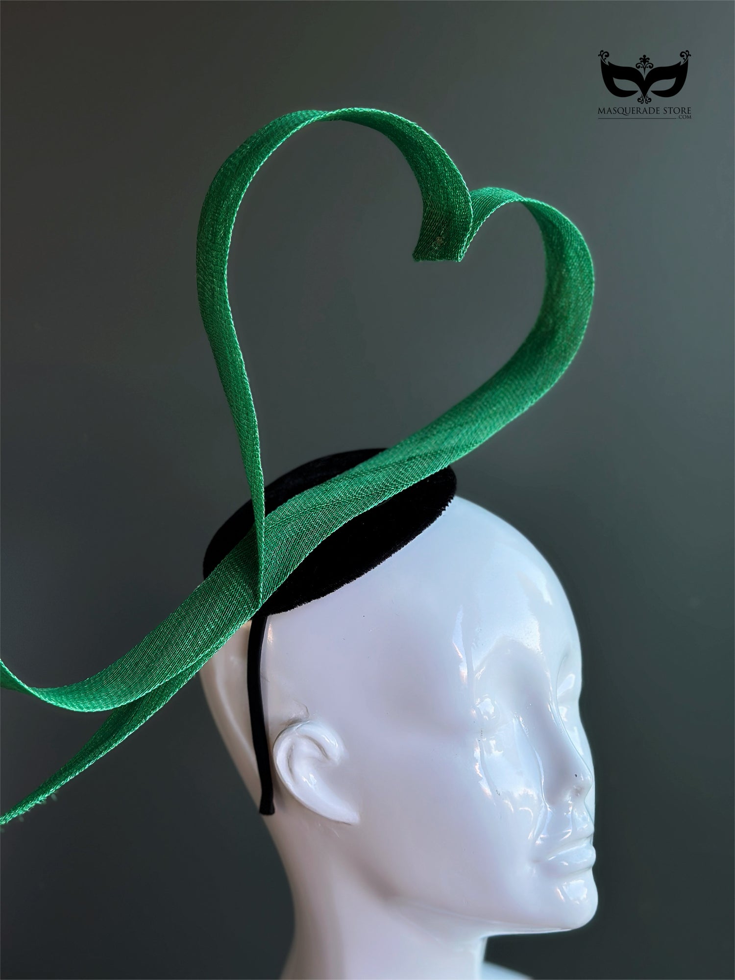 Green heart loop fascinator headband with sculptural ribbon design on mannequin