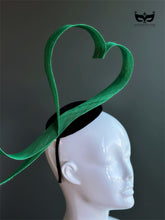 Green heart loop fascinator headband with sculptural ribbon design on mannequin