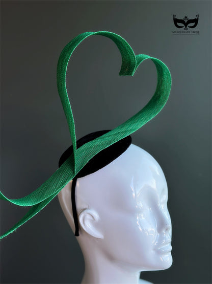 Green heart loop fascinator headband with sculptural ribbon design on mannequin