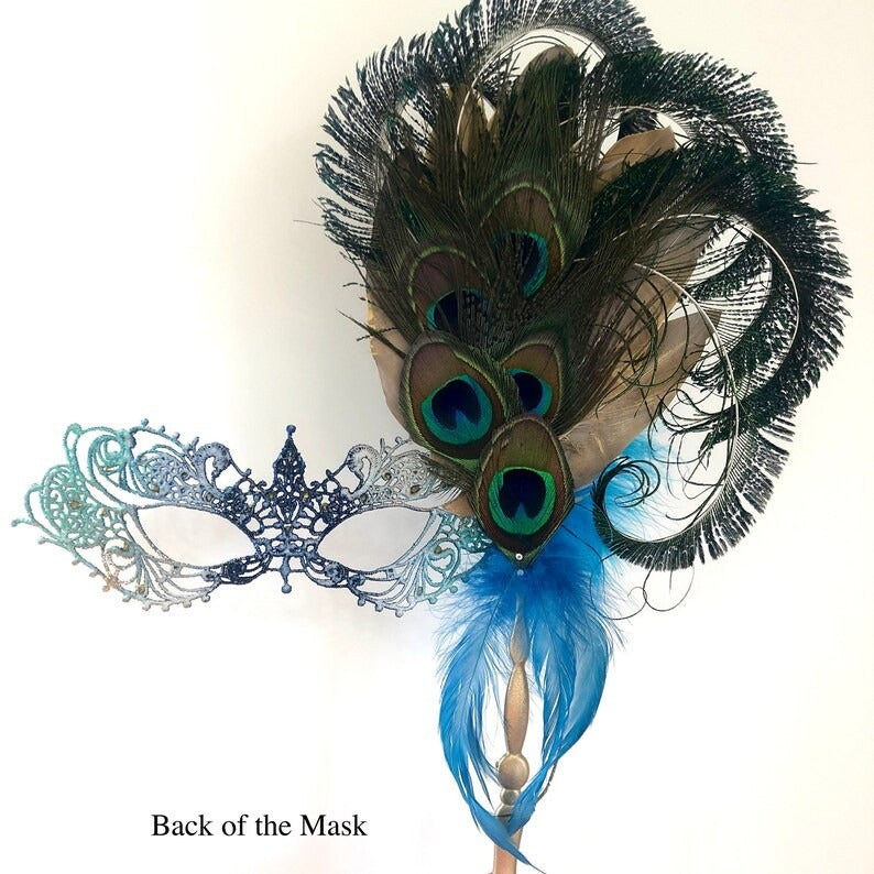 Venetian handheld masquerade mask with peacock feathers, jeweled details, and blue feather plumes.