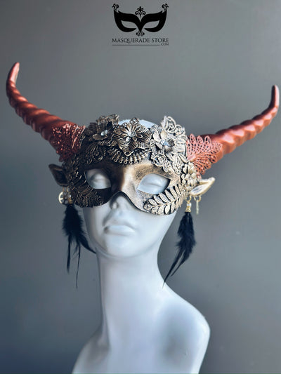 Horned masquerade mask with bronze floral details, copper sculpted horns, and feather accents, perfect for fantasy balls or cosplay events.