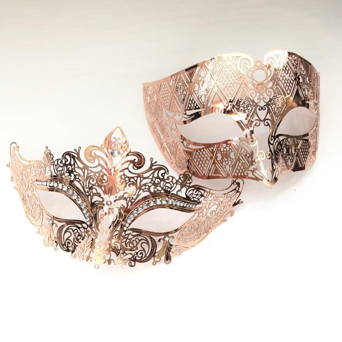 Couples masquerade masks in rose gold laser-cut metal and rhinestones on the women&