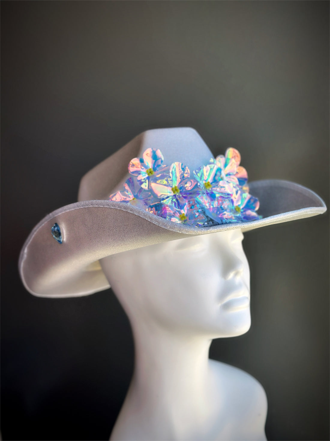 Silver cowgirl hat with iridescent flower embellishments and rhinestone trim.

