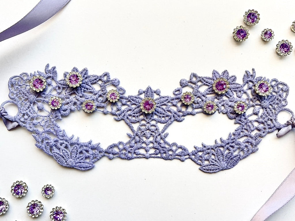 Lavender embroidered lace Venetian masquerade eye mask featuring amethyst crystal rhinestones and satin ribbon ties. Perfect for masquerade balls, Mardi Gras celebrations, weddings, bridal showers, black tie galas, Renaissance festivals, opera performances, cosplay, Valentine&