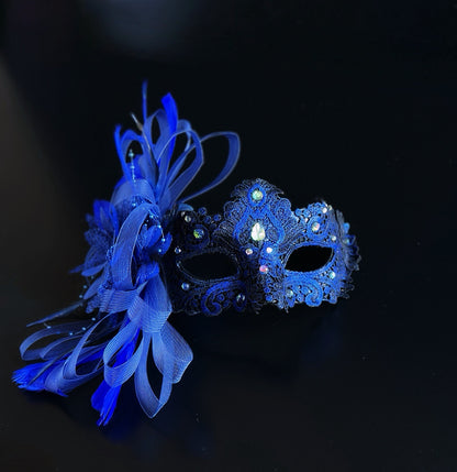 Royal blue lace masquerade mask with crystals and feather accent for formal balls and gala events.