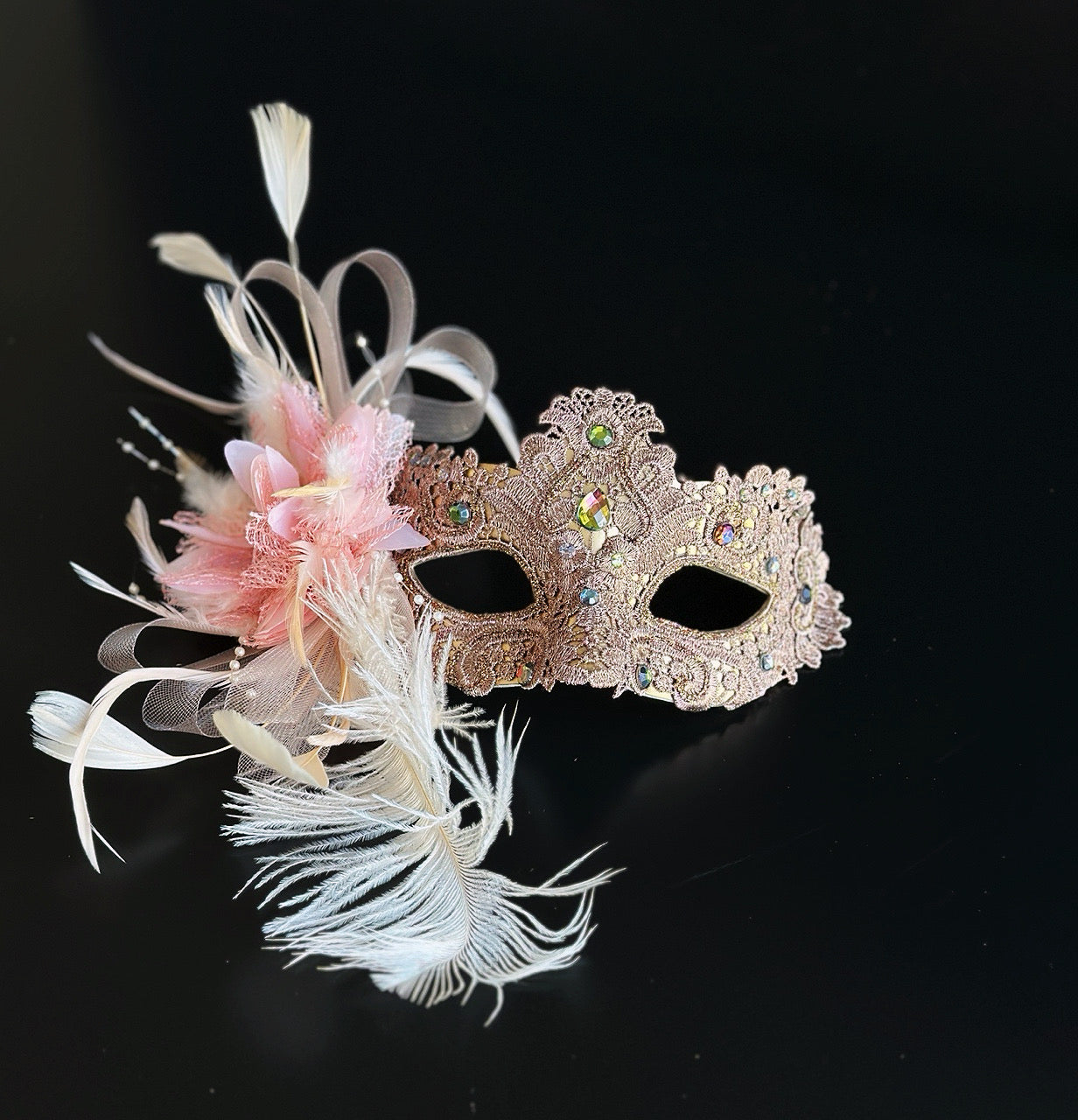 Blush pink and gold lace masquerade mask with feathers and crystals for weddings, galas, and formal masquerade occasions.
