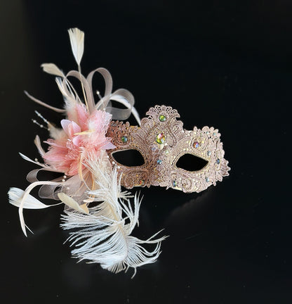 Blush pink and gold lace masquerade mask with feathers and crystals for weddings, galas, and formal masquerade occasions.