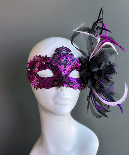 Purple lace masquerade mask with crystal embellishments and black detail styled for masquerade balls and formal events.