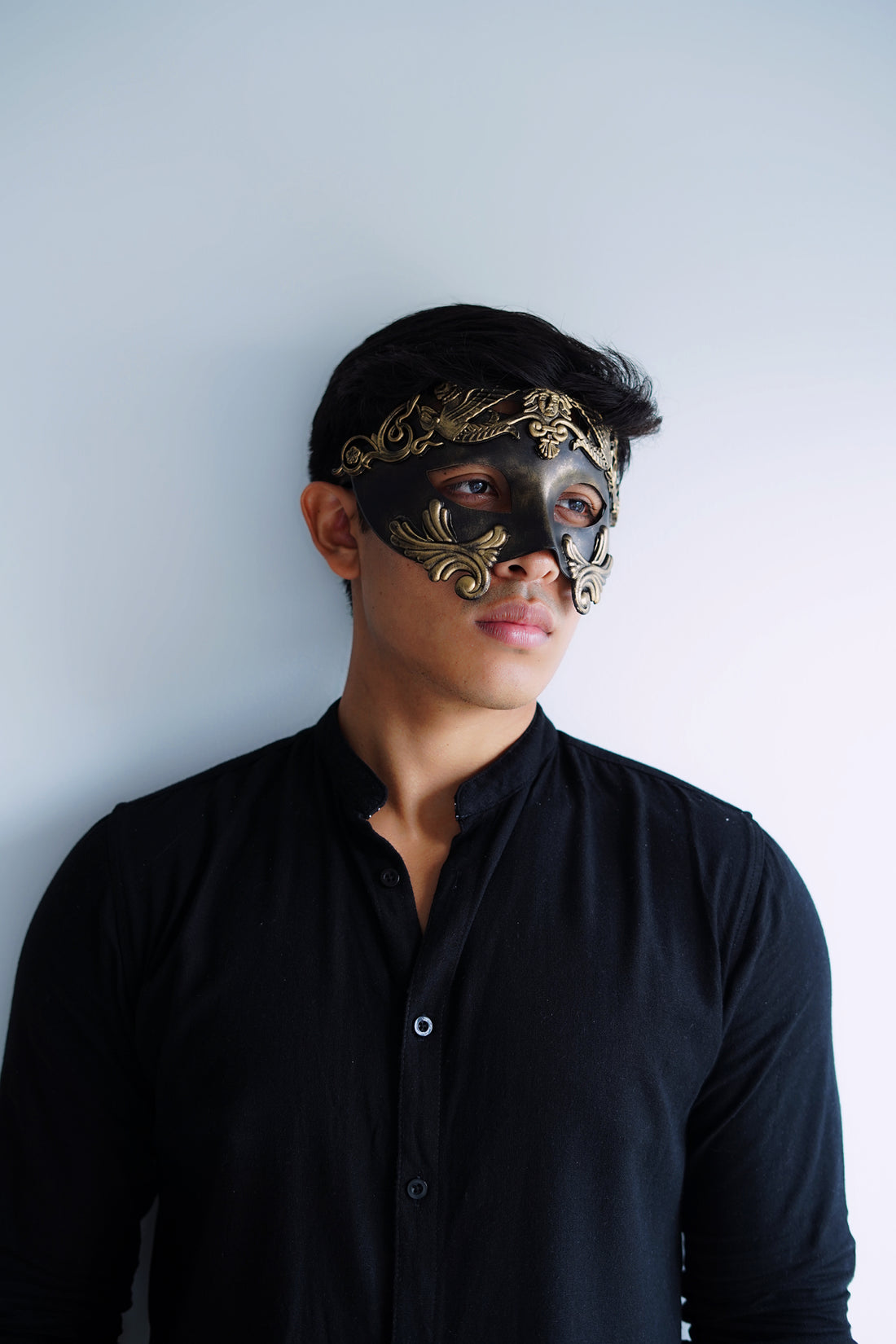 Men’s black and gold masquerade mask with filigree baroque design.