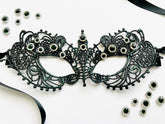 Black embroidered lace Venetian masquerade eye mask featuring emerald green crystal rhinestones and satin ribbon ties. Ideal for masquerade balls, Mardi Gras celebrations, gothic weddings, black tie galas, Renaissance festivals, opera performances, cosplay, Halloween parties, and formal costume events.