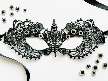 Black embroidered lace Venetian masquerade eye mask featuring emerald green crystal rhinestones and satin ribbon ties. Ideal for masquerade balls, Mardi Gras celebrations, gothic weddings, black tie galas, Renaissance festivals, opera performances, cosplay, Halloween parties, and formal costume events.