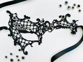 Black embroidered spiderweb lace masquerade mask with sparkling black rhinestones and satin ribbon ties. Perfect for Halloween, gothic costumes, masquerade balls, vampire cosplay, Venetian masquerade events, Mardi Gras celebrations, theatrical performances, gothic weddings, fantasy costumes, and elegant evening wear.