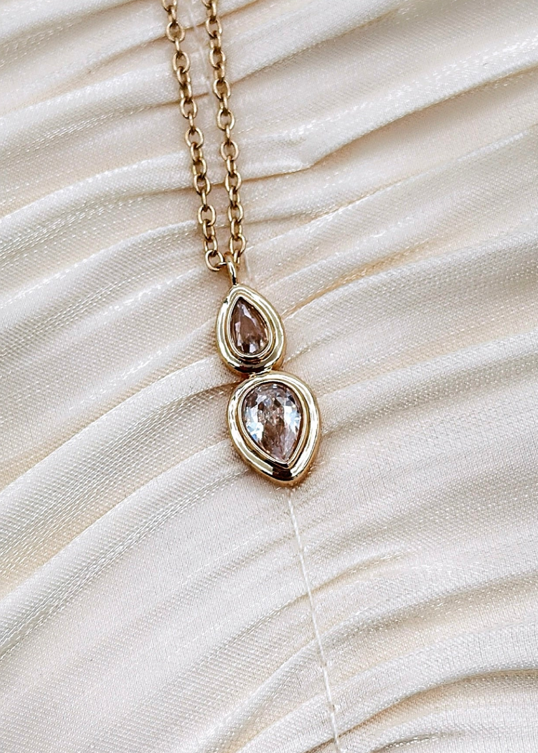 Gold plated chain with two teardrop-shaped gemstone pendant.