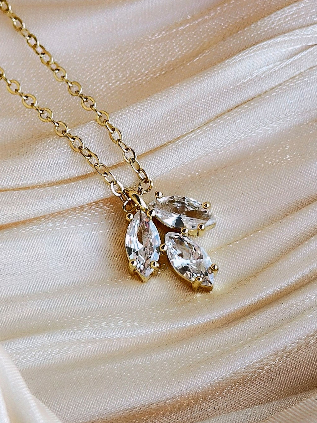 Gold necklace with a trio of clear marquise cut crystals.