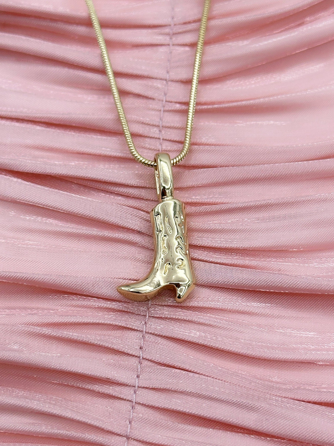 Gold cowboy boot pendant on a gold-plated chain.