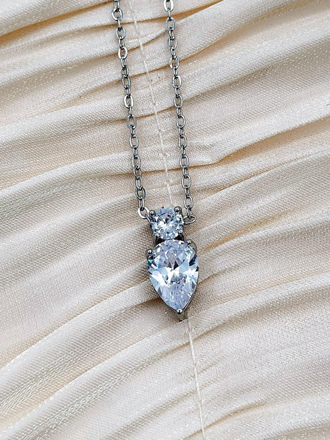 Pear and circle cut crystals on a silver-plated chain.