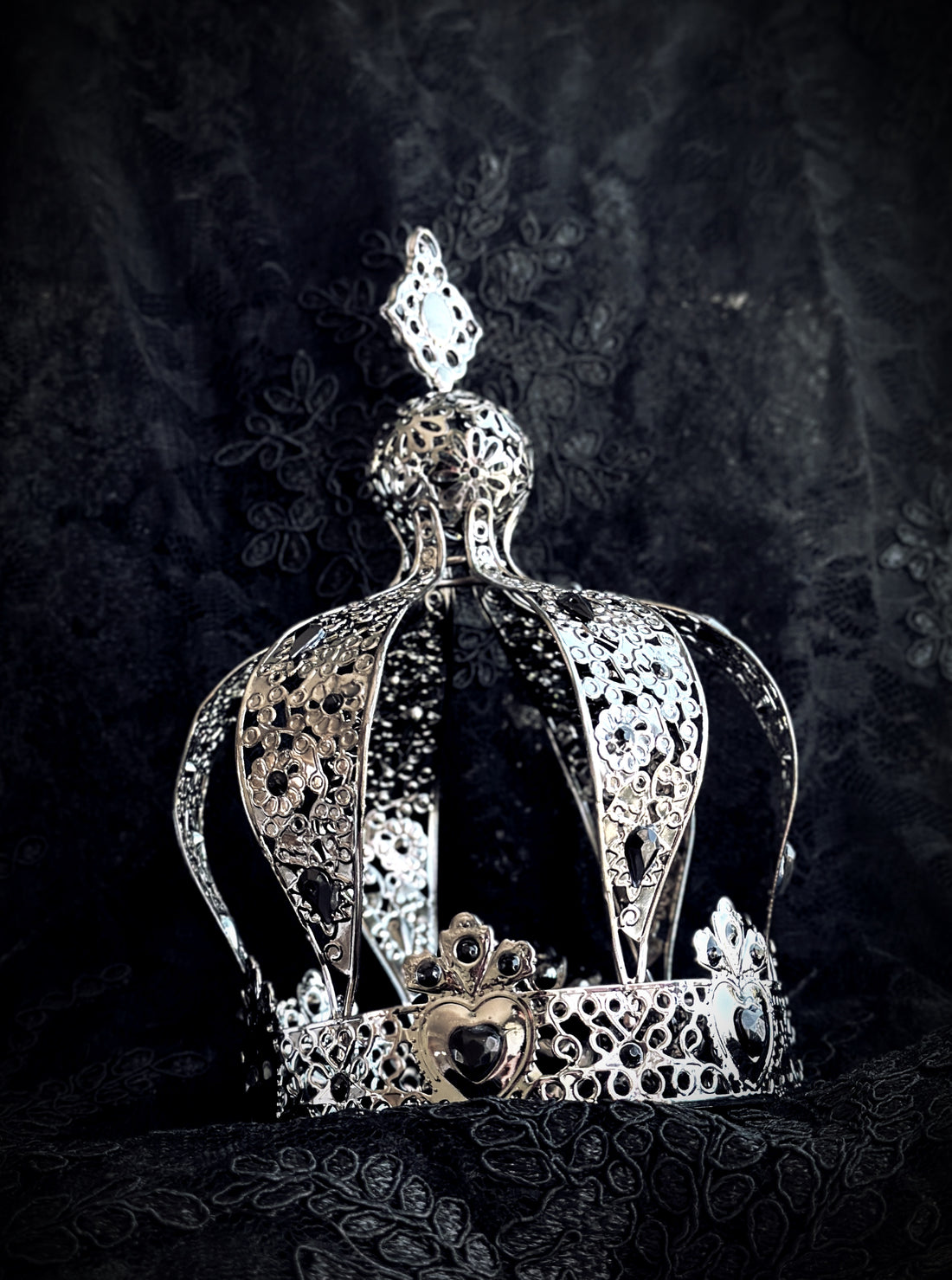 silver gothic crown with filigree hearts and dark gemstone centerpiece