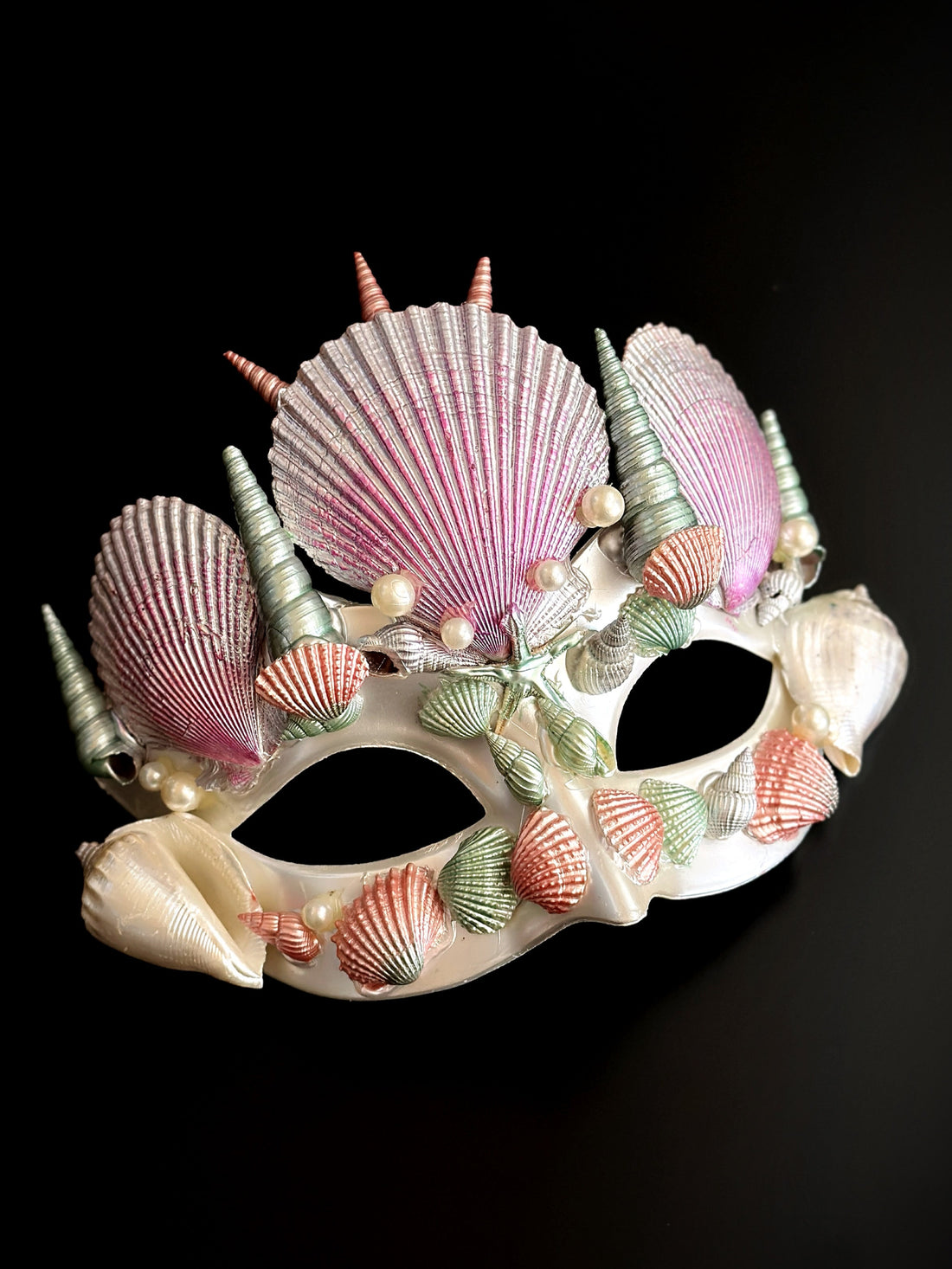 Pastel masquerade mask with mint, pink, and coral seashells in a mermaid-inspired design.