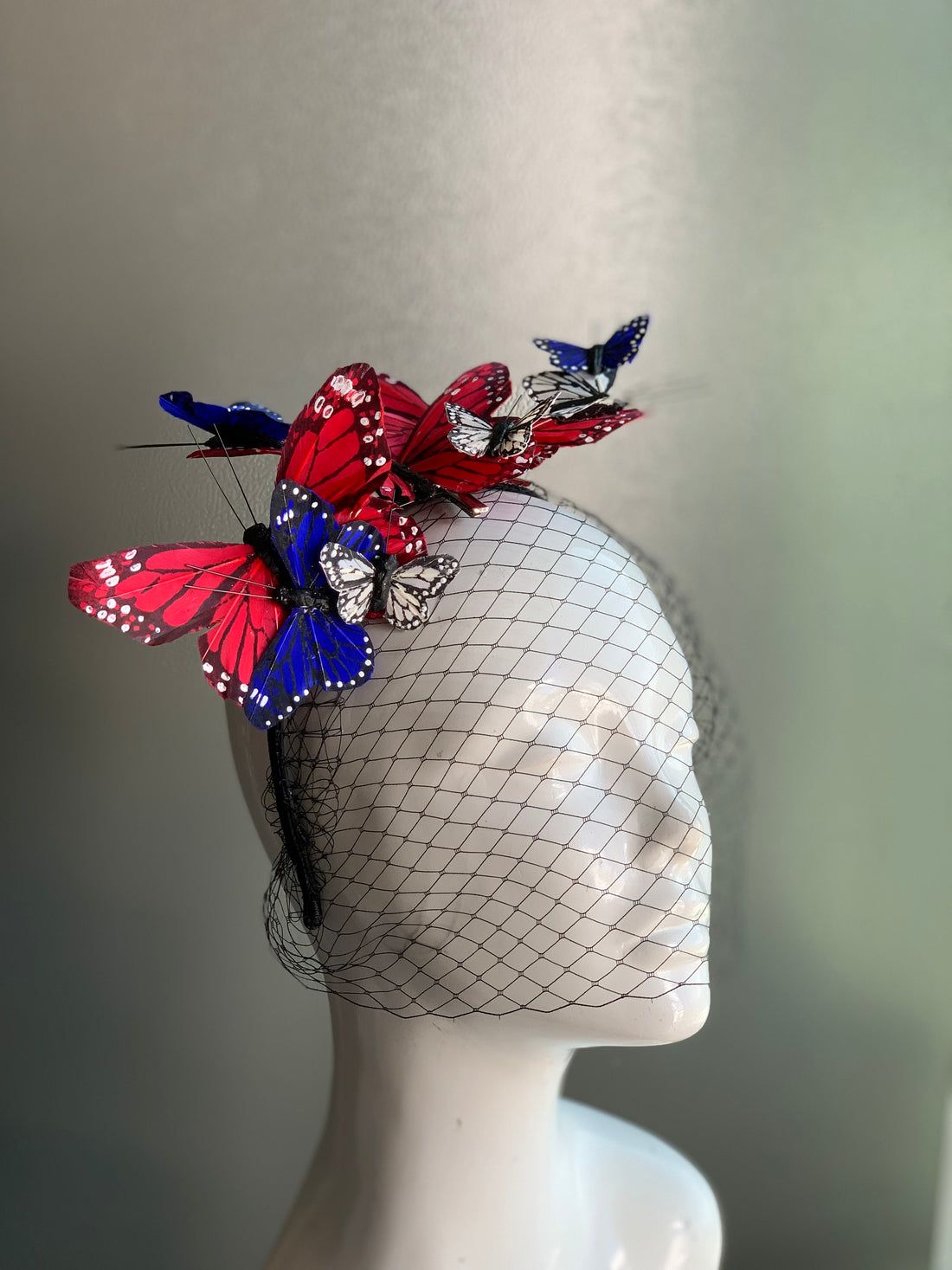 Patriotic butterfly fascinator with red, white, and blue butterflies and a black netted veil.