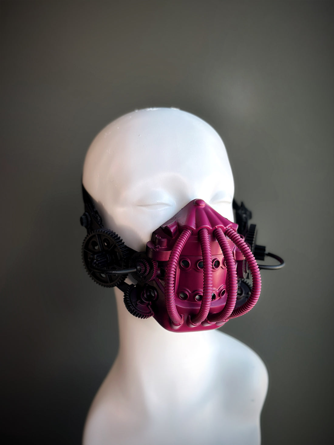 Pink and black steampunk respirator mask with gears and tubing, ideal for gothic, cyberpunk, and cosplay fashion.

