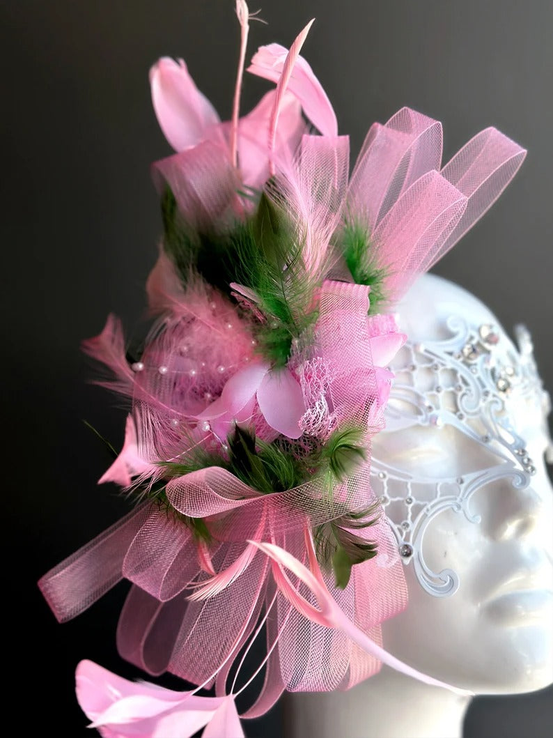 Elegant white lace masquerade mask with pink feathers and rhinestones for women’s prom, carnival, and party looks.