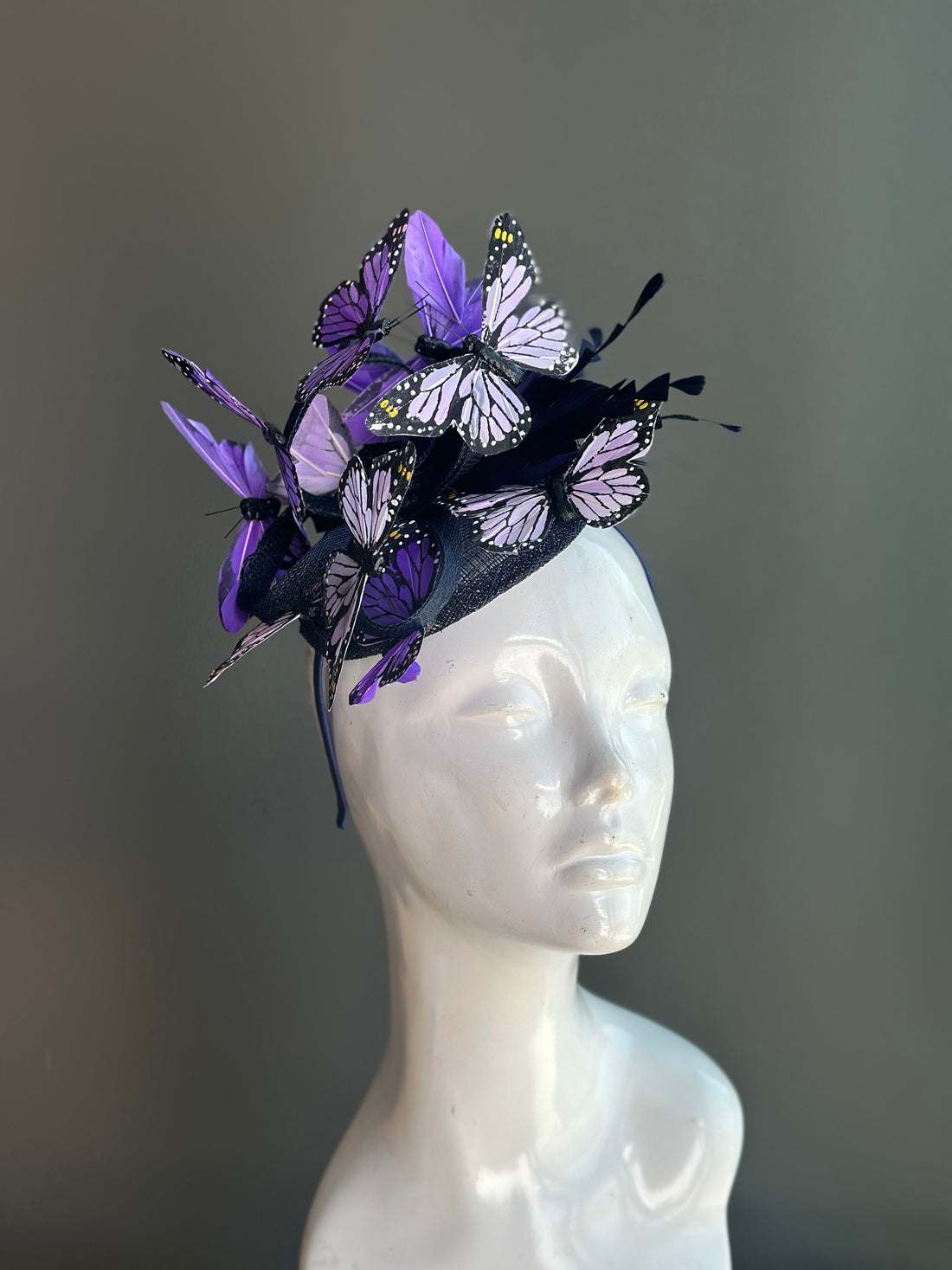 Purple butterfly fascinator hat with delicate butterfly accents, perfect for weddings, garden parties, or races.