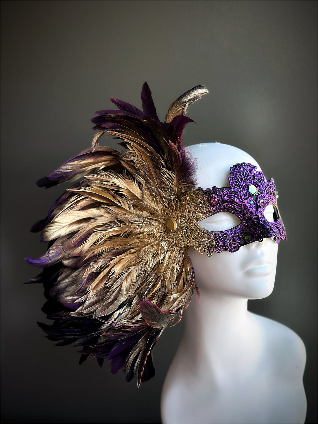 Purple and gold Venetian mask with side plume of layered feathers and ornate lace detailing