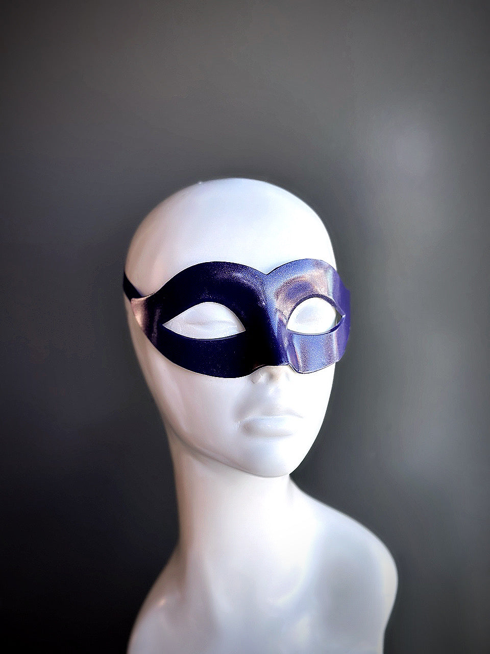Sleek purple Venetian eye mask with a smooth finish, displayed on a mannequin.

