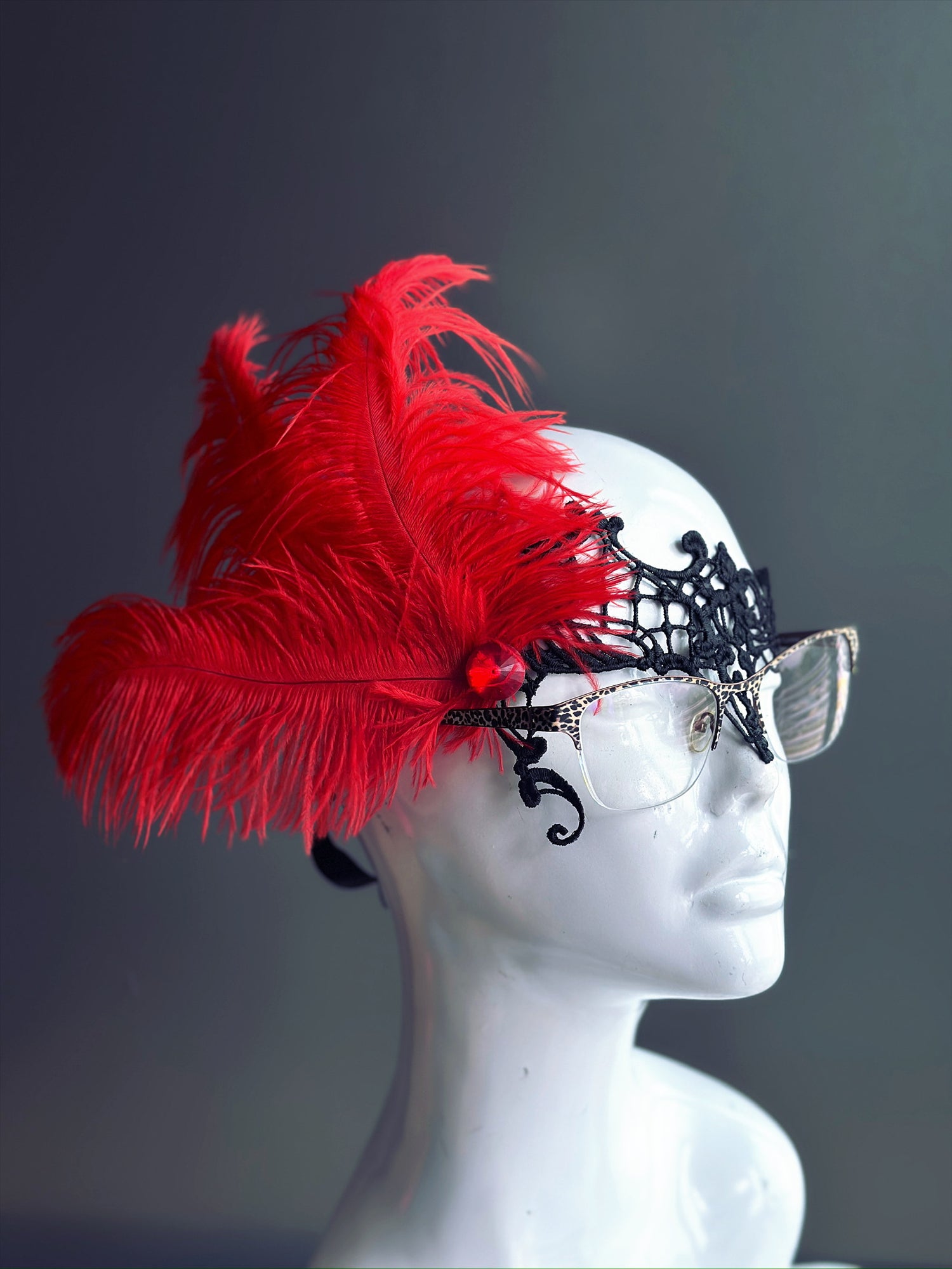 Red Feather Masquerade Mask with black lace, designed to fit over glasses, adorned with striking red feathers.