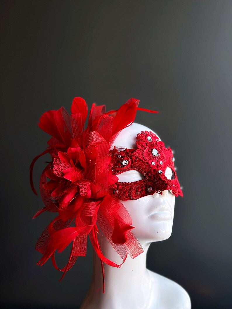 Elegant red lace mask with feathers, rhinestones, and ribbons for Valentine’s, masquerade balls, and prom.