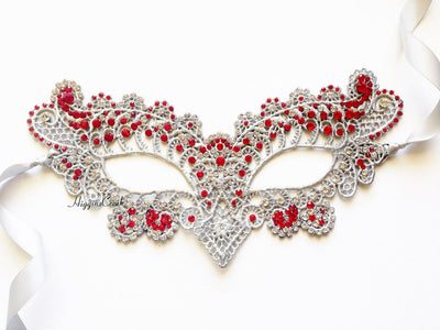 Silver lace masquerade mask adorned with red rhinestones and ribbon ties