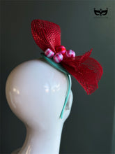 Red bow holiday fascinator headband with mesh loops and ornament bead accents on mannequin