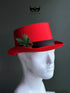 Red Christmas top hat with pine greenery pinecone accent for holiday outfits and winter parties