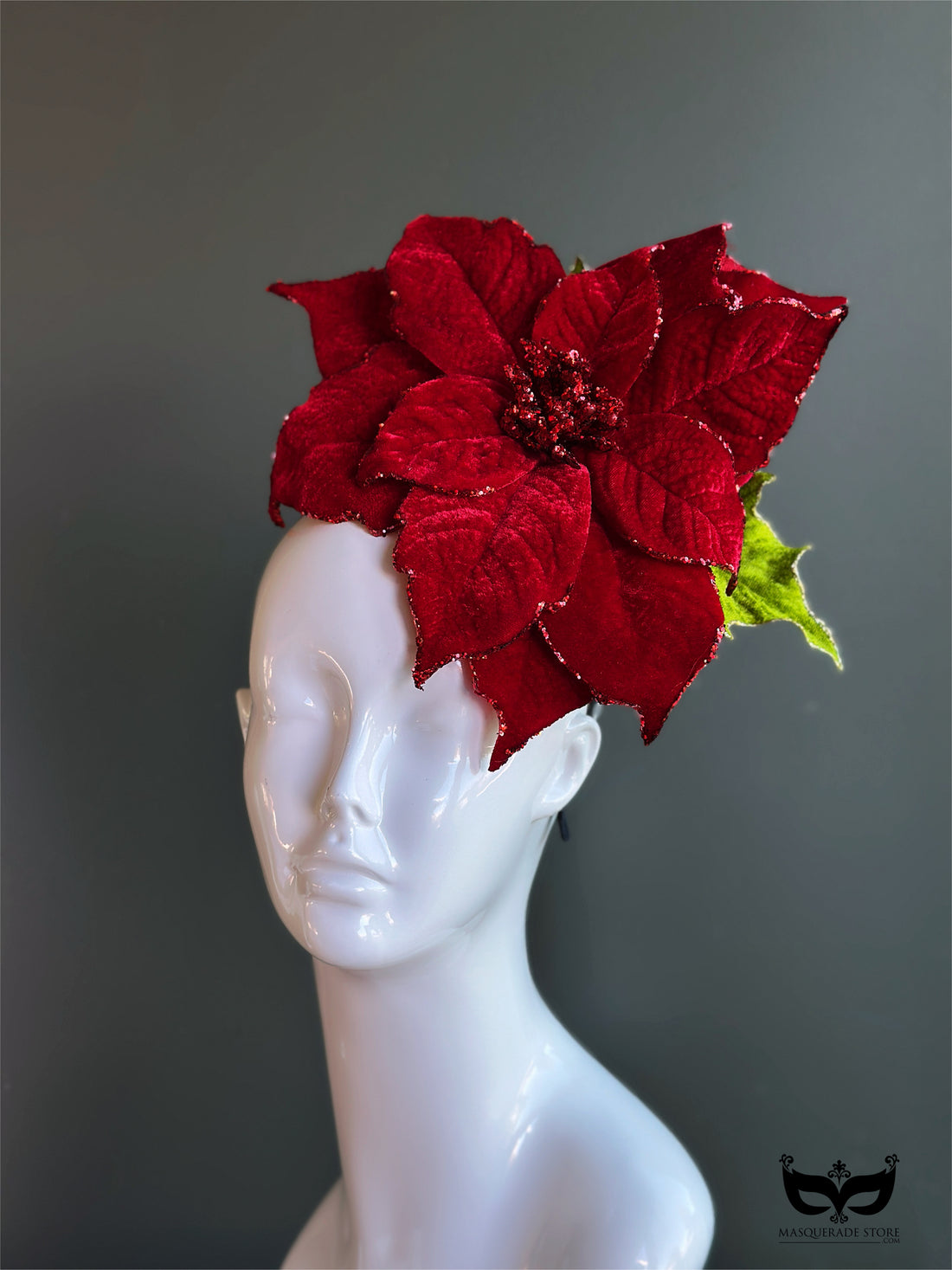 Red poinsettia holiday fascinator hat with layered velvet petals on mannequin