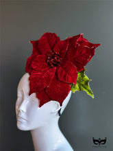 Red poinsettia holiday fascinator hat with layered velvet petals on mannequin