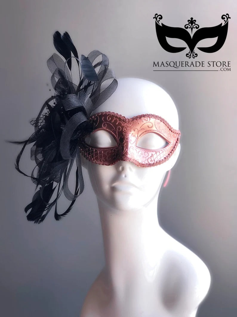 Elegant rose gold masquerade mask with black feathers and ribbon side accent, Venetian style.